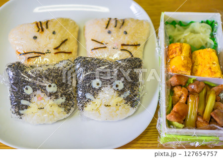 ラップを巻いた猫型のおにぎり弁当 127654757