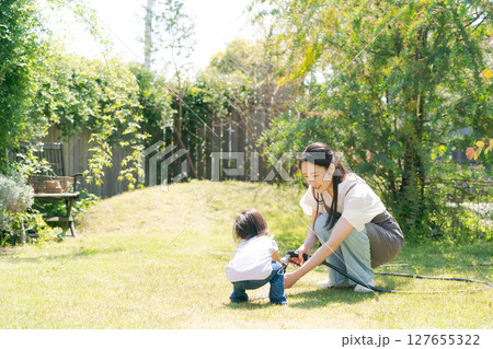 緑あふれる庭で遊ぶ親子 127655322