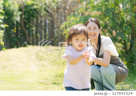 緑あふれる庭で遊ぶ親子 127655324