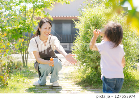 自然あふれる庭で遊ぶ親子 127655974