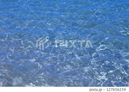 Surface of Clear Deep Blue Red Sea Water with Sunlight Reflections and Underwater Ripples 127656259