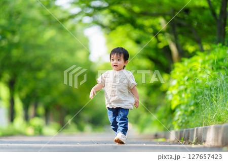 公園の並木道で走る1歳の男の子 公園の並木道で走る1歳の男の子 127657423