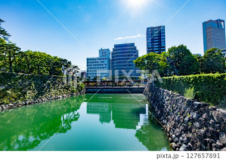 香川県、史跡高松城跡玉藻公園の石垣とお堀とビル群 127657891
