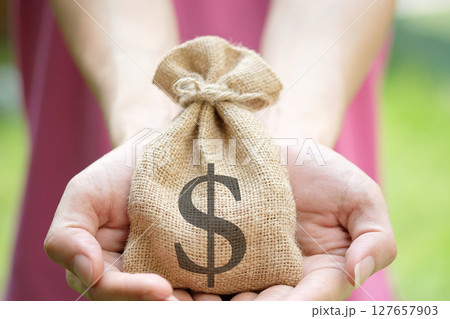 Hand of a woman carrying a purse money .concept saving money and investment concept 127657903