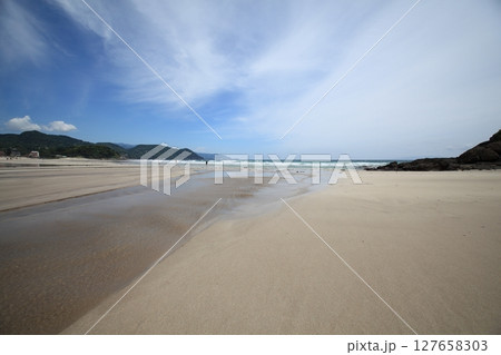 砂浜に続く砂浜にできた風紋の後と水の流れ込む風景 127658303