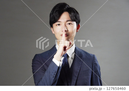 ビジネスマン　秘密のポーズ　黒背景 127658460