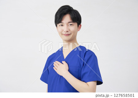 医者・看護師・歯科医師・介護士　胸に手を置く男性　ポートレート　白背景　カメラ目線 127658501
