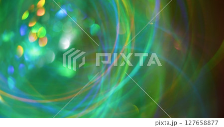 Green glow. Blur radiance. Multicolored orange blue yellow lines sparks lens flare on bokeh light abstract optical background. Green glow. Blur radiance. Multicolored orange blue yellow lines sparks lens flare on bokeh light abstract optical background. 127658877