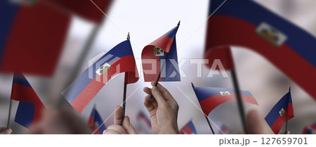 Haiti flags in their hands on a blurred urban background Haiti flags in their hands on a blurred urban background 127659701