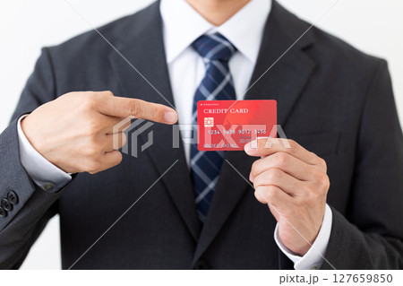 クレジットカードを指差すスーツ姿のビジネスマン男性 クレジットカードを指差すスーツ姿のビジネスマン男性 127659850