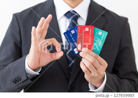 クレジットカードを持って丸サインをするスーツ姿のビジネスマン男性 127659985