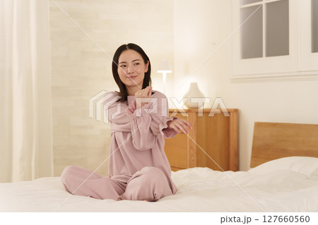 夜ベッドでストレッチする女性 127660560