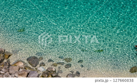 Crystal clear turquoise water gently hitting the rocky shore in Tropea, Calabria, Italy Crystal clear turquoise water gently hitting the rocky shore in Tropea, Calabria, Italy 127660838