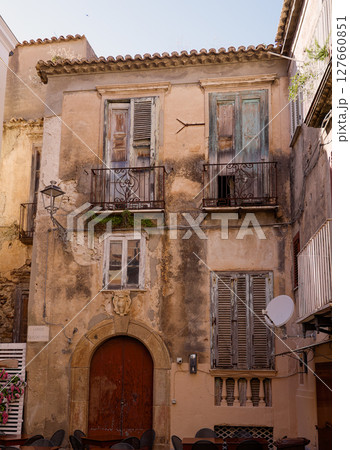 Old weathered building with balconies and closed shutters in Tropea, Italy 127660851