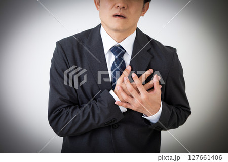 胸を押さえて苦しむスーツ姿のミドル男性ビジネスマン 127661406