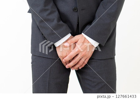 股間を押さえて苦しむスーツ姿のミドル男性ビジネスマン 127661433