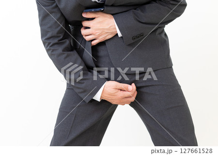 股間の痒みに苦しむスーツ姿のミドル男性ビジネスマン 127661528