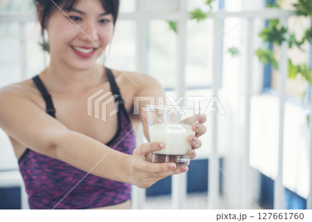 Asian women smile laugh look at camera health care home fitness lifestyle. Beautiful female drinking fresh milk low-fat dairy free lactose. Women hands holding white glass of milk pouring from bottle Asian women smile laugh look at camera health care home fitness lifestyle. Beautiful female drinking fresh milk low-fat dairy free lactose. Women hands holding white glass of milk pouring from bottle 127661760