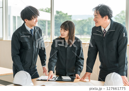 打ち合わせ,ミーティングをする作業着姿の建設業,建築業の男女のビジネスマン 127661775