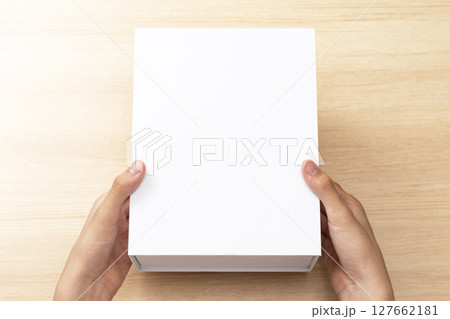 白い箱を持つ手元 127662181