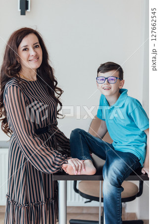 Brunette mom hugging her son with glasses Brunette mom hugging her son with glasses 127662545
