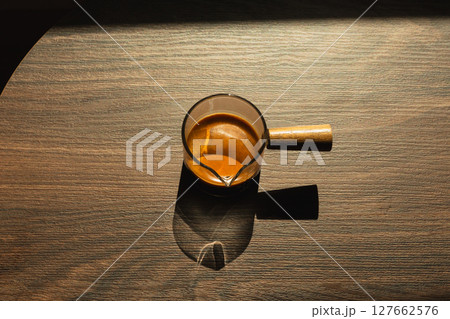 Espresso coffee in a glass cup on a dark background in vertical. 127662576