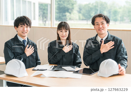 会議室に座る作業着,作業服姿のビジネスマン男女(安心,信頼) 会議室に座る作業着,作業服姿のビジネスマン男女(安心,信頼) 127663229