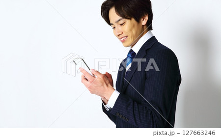 笑顔でスマホを操作する男性会社員イメージ 127663246