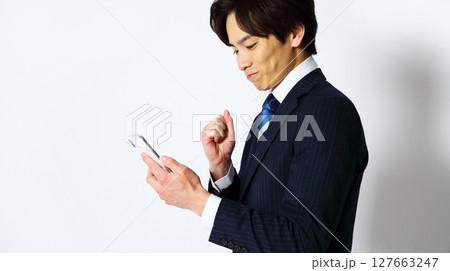 笑顔でスマホを操作する男性会社員イメージ 127663247
