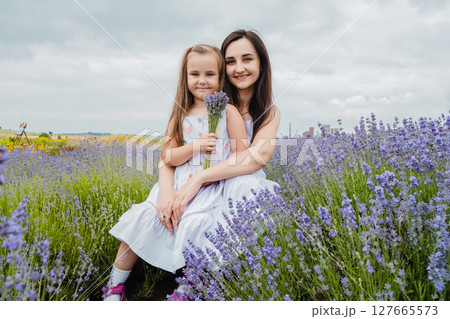 In the lavender field, a mother and her daughter are together In the lavender field, a mother and her daughter are together 127665573