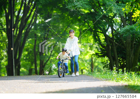 自転車の練習をする5歳の男の子とフォローする母親 127665584