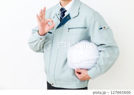 グリーンの作業服を着てヘルメットを持ち丸サインをするミドル男性ビジネスマン 127665600