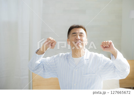 寝室で元気に目覚めるシニア男性 寝室で元気に目覚めるシニア男性 127665672