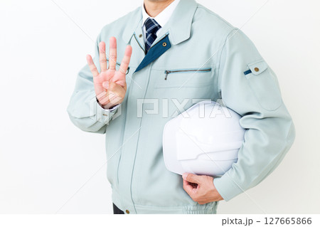 グリーンの作業服を着てヘルメットを持ち指を4本立てるミドル男性ビジネスマン 127665866