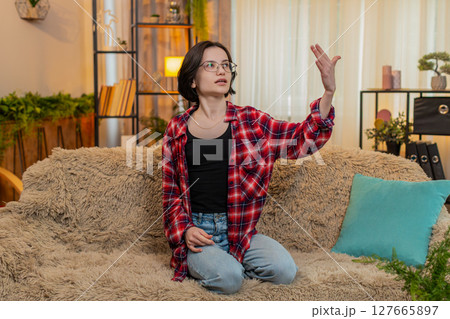 Young woman rehearsing monologue at home, gesturing with emotion and full theatrical engagement Young woman rehearsing monologue at home, gesturing with emotion and full theatrical engagement 127665897
