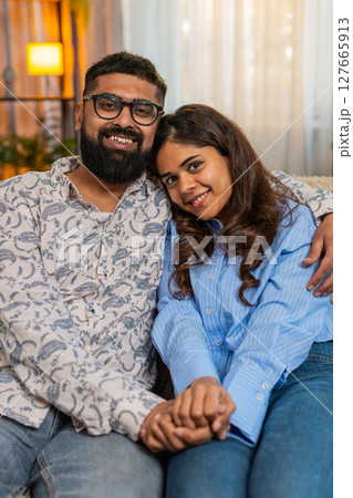 Indian family couple man woman holding hands sit in silence at home, sharing peaceful emotional bond 127665913