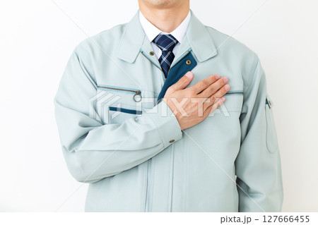 グリーンの作業服を着て胸に手を当てるミドル男性ビジネスマン 127666455