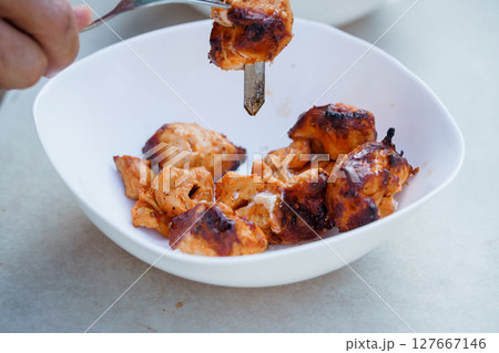 Flavorful Tandoori Chicken Bites on a White Plate, Close-Up, Red Spices, Rustic Presentation, Culinary Photography, Foodie Lifestyle. 127667146