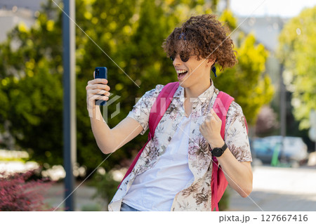 Man using mobile smartphone celebrating win good message news lottery jackpot victory casino app 127667416