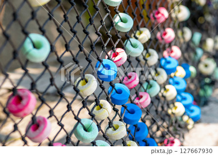 Colorful and round soft decorations on the net fence Colorful and round soft decorations on the net fence 127667930