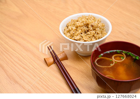 木目テーブル背景の茶碗に玄米ごはんと味噌汁 木目テーブル背景の茶碗に玄米ごはんと味噌汁 127668024