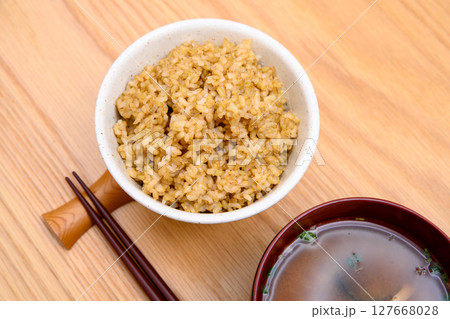 木目テーブル背景の茶碗に玄米ごはんと味噌汁 木目テーブル背景の茶碗に玄米ごはんと味噌汁 127668028