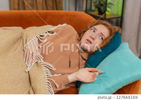Woman suddenly wakes up from nightmare while sleeping on couch due to anxiety, disorder, bad dreams 127668169