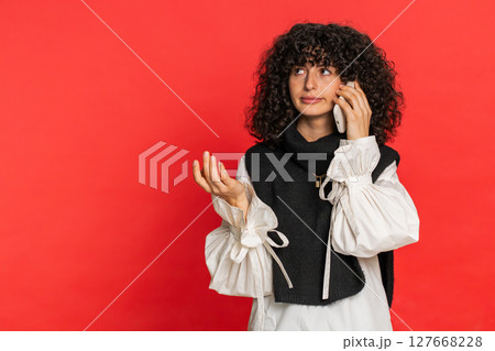 Disinterested tired woman having annoyed boring talk on smartphone online conversation quarrel Disinterested tired woman having annoyed boring talk on smartphone online conversation quarrel 127668228