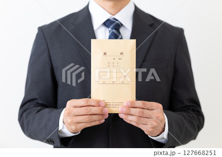 給料袋を持つスーツ姿のミドル男性ビジネスマン 127668251