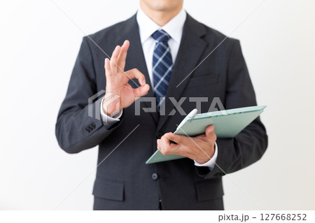 バインダーを持って丸サインをするスーツ姿のミドル男性ビジネスマン 127668252