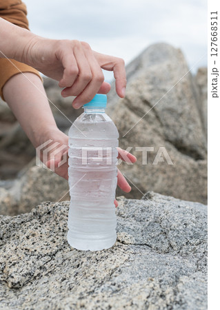 ペットボトルの水を持っている人 127668511