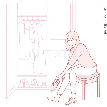 A Woman Enjoys Trying on Shoes in a Cozy and Inviting Closet Setting filled with Style 127668536