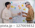 senior programmer bootcamlp,Asian young instructor guides senior learners through a programming on whiteboard, highlighting algorithm thinking and simple code exercises 127669832
