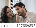 Supportive couple in emotional moment at home as woman struggles with sadness and stress, expressing 127669837